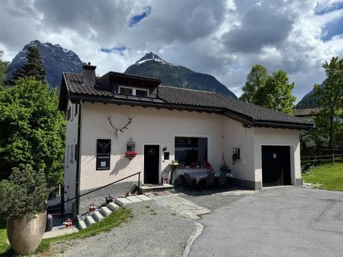 a white house with a table in front of it at Ferienhaus Meis Chalet in Scuol
