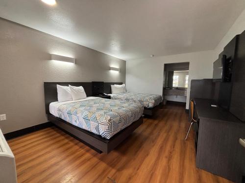 a hotel room with two beds and a television at Motel 6-Sulphur, LA in Sulphur