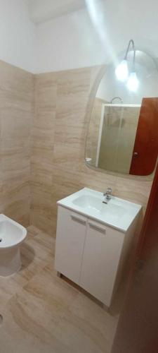 a bathroom with a white sink and a mirror at Casa dos Buizinhos in Porto Covo