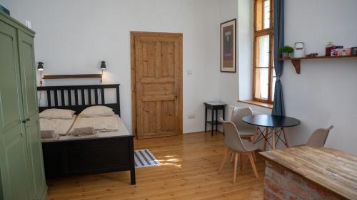 Un dormitorio con una cama y una mesa y sillas. en Mokka Vendégház, en Kismaros