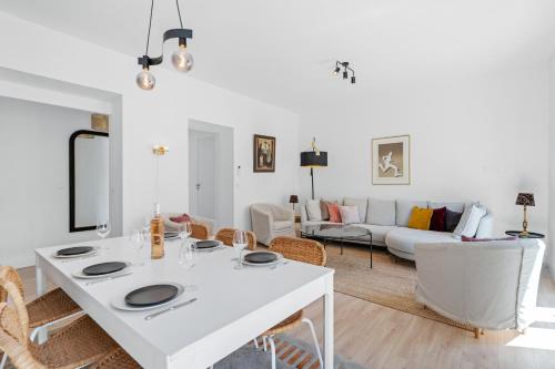 un salon blanc avec une table et des chaises blanches dans l'établissement Le Botta, spacieux appartement famillial, centre ville de Menton, jardins Biovès, à 5 minutes de la mer, à Menton