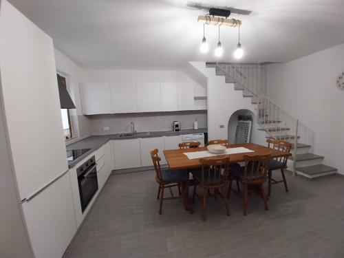 une cuisine et une salle à manger avec une table et des chaises dans l'établissement Fpo-Fio42tp Casa su due Piani, 6 Pax A Ottiolu, à Porto Ottiolu