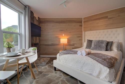 una camera con letto, tavolo e tavolo di Detente Nature bord de Lac #4 - Spa Sauna & Foyer a Sainte Brigitte de Laval