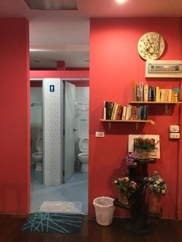 baño con aseo y pared roja en Honey Place Guesthouse,special rate for long stay, en Bangkok