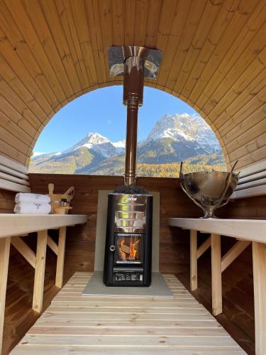 a stove in a cabin with a view of mountains at Ferienhaus Meis Chalet in Scuol