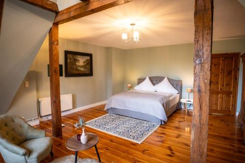 a bedroom with a bed and a chair at Gut Alt Necheln in Brüel