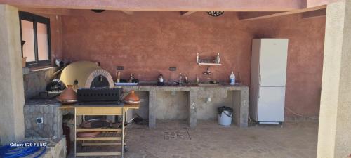 a kitchen with a stove and a refrigerator in a room at Le calme de la campagne, le souffle de l'océan in Khemis du Sahel