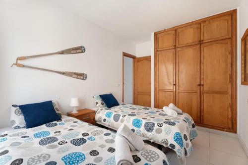 a bedroom with two beds and a closet at La Arena By Médano Rentals in El Médano