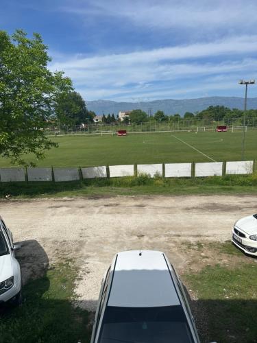 a white car parked in a parking lot with a soccer field at Schöne Suite in Trikala Grichenland in Pýrgos