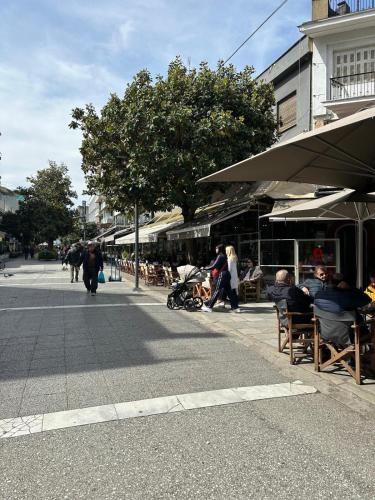 a group of people sitting in chairs on a street at Schöne Suite in Trikala Grichenland in Pýrgos