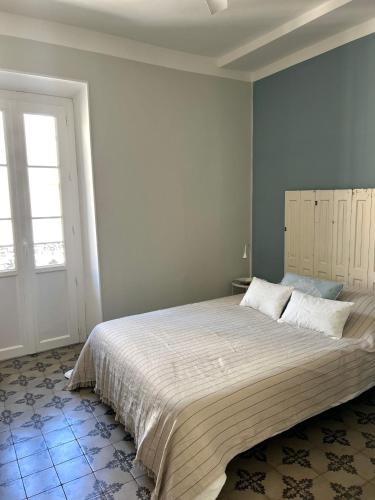une chambre avec un grand lit et une fenêtre dans l'établissement Maison Paulette - charme et authenticité, à Bizanet