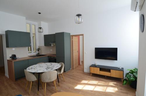 une cuisine avec une table et des chaises dans une pièce dans l'établissement JAURES - Luxueux appartement quartier Vieux-Nice, à Nice