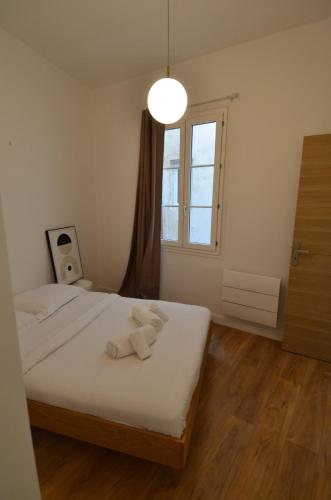 une chambre avec un lit avec des draps blancs et une fenêtre dans l'établissement JAURES - Luxueux appartement quartier Vieux-Nice, à Nice