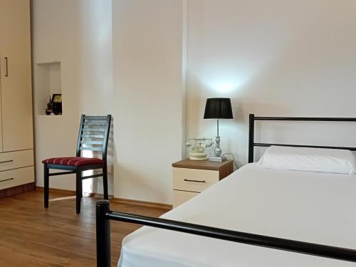 a bedroom with a bed and a red chair at Arbinovo Lodge in Ohrid