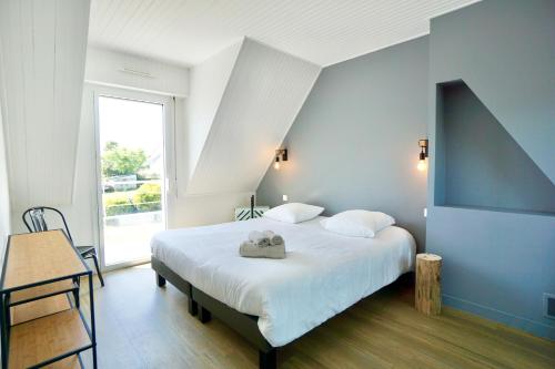une chambre avec un grand lit blanc et une fenêtre dans l'établissement Le cottage bleu - 400 m de la mer - parking, à Larmor-Plage