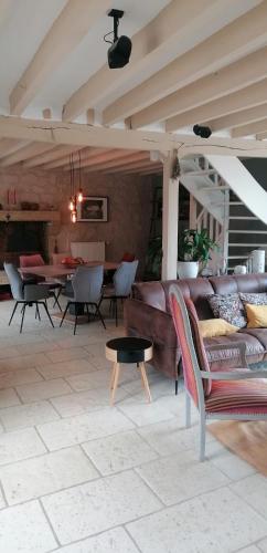 un salon avec un canapé et une table dans l'établissement Charmante maison de campagne très agréable avec sa piscine chauffée, terrasse, jardin,, à La Celle-sous-Gouzon