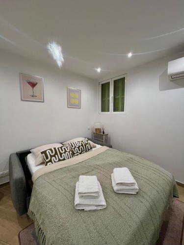 une chambre avec un grand lit avec des serviettes dessus dans l'établissement Studio - Le Berlioz - City Center, à Nice