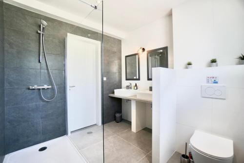 une salle de bain avec une douche, des toilettes et un lavabo dans l'établissement Le cottage bleu - 400 m de la mer - parking, à Larmor-Plage