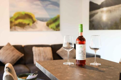 a bottle of wine sitting on a table with two wine glasses at Ferienhaus Henneglück3 mit Sauna in Meschede