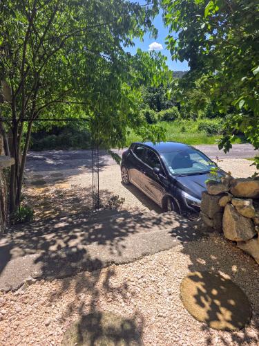 a car parked in a parking lot next to a tree at L'uzanges in Lussan