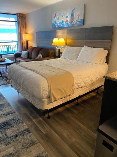 a bedroom with a large bed and a couch at Laidback n Lazy at Landmark Resort in Myrtle Beach