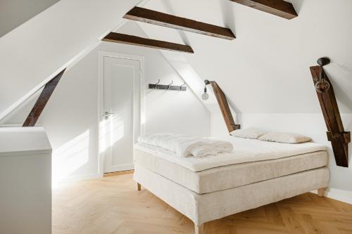 a bedroom with white walls and wooden beams at Bergen City Living in Bergen