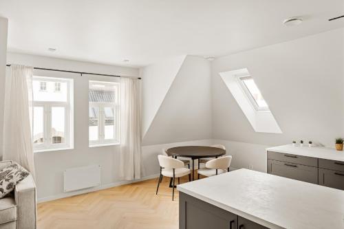 a white kitchen with a table and chairs at Bergen City Living in Bergen