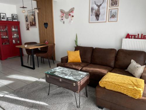a living room with a brown couch and a table at L‘atelier in Châtenois