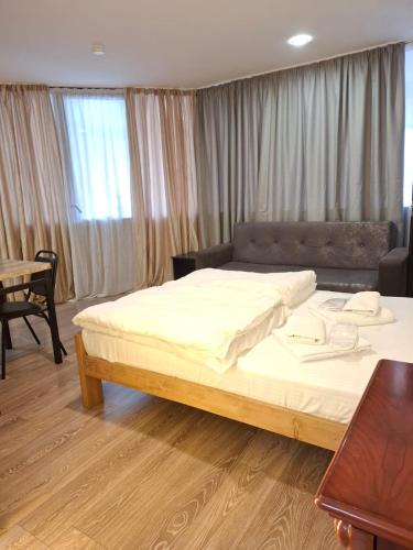 a bedroom with a large bed and a table at Aura Plaza Hotel in Tbilisi City