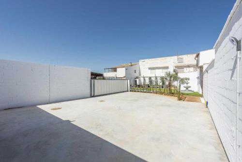 an empty parking lot next to a white building at Casa Rural Maimones in Los Pérez