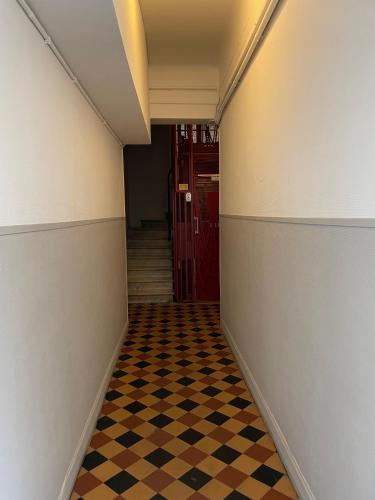 un couloir avec un sol en damier et une porte rouge dans l'établissement Charming Riviera Top-Floor Apartment near the Beach, à Nice