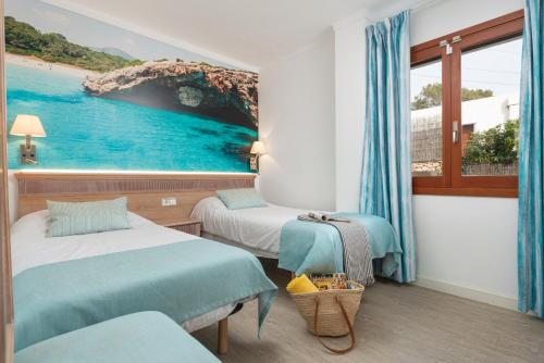 pokój z 2 łóżkami i obrazem plaży w obiekcie Apartamentos Playa Marina w mieście Cala Ferrera