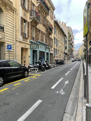 une rue avec des voitures garées sur le bord de la route dans l'établissement Charming Riviera Top-Floor Apartment near the Beach, à Nice