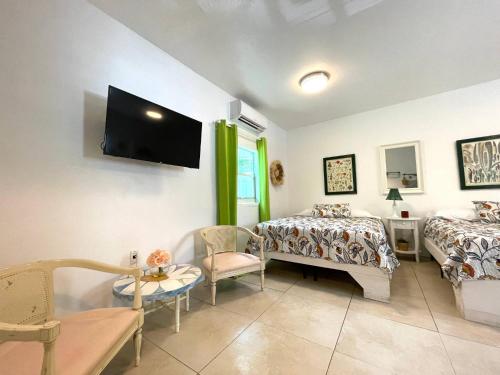 a bedroom with two beds and a tv on the wall at Unique Studio in Little Havana Reserved Parking in Miami