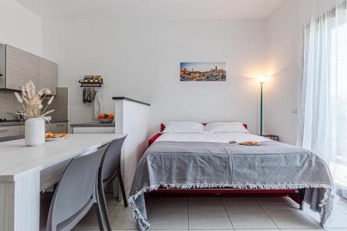 a bedroom with a bed and a kitchen with a desk at il terrazzino di Marco e Francesca in Siena