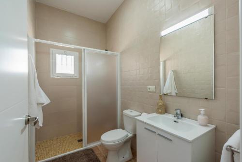 a bathroom with a toilet and a sink and a shower at Casa Rural Maria in La Lantejuela