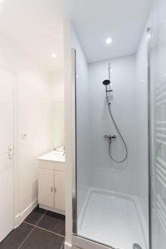 une salle de bain blanche avec une douche et un lavabo dans l'établissement Le Scandi Bleu - Proche Gare Corbeil - Cozy Houses, à Corbeil-Essonnes