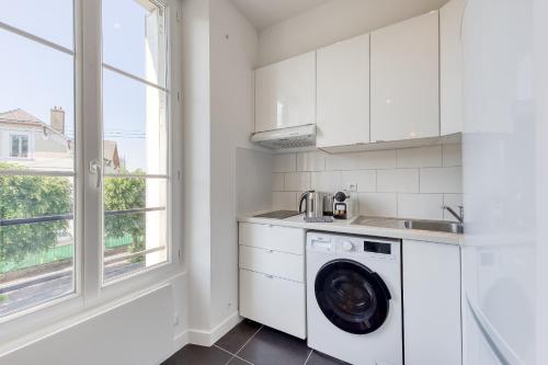 a kitchen with a washing machine and a window at Le Scandi Bleu - Proche Gare Corbeil - Cozy Houses in Corbeil-Essonnes