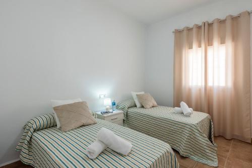two beds with towels on them in a room at Casa Rural Maria in La Lantejuela