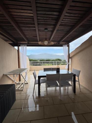Un comedor con mesa y sillas en un patio. en Appartement dans résidence standing, en Porto Vecchio