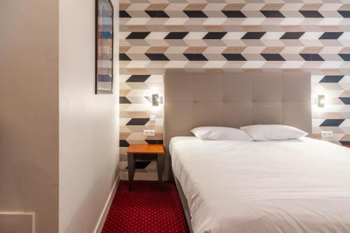 a bedroom with a white bed and a red carpet at Logis Le Relais de Fusies in Lacaune