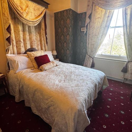 a bedroom with a large bed with a window at The Sycamore Guest House in York