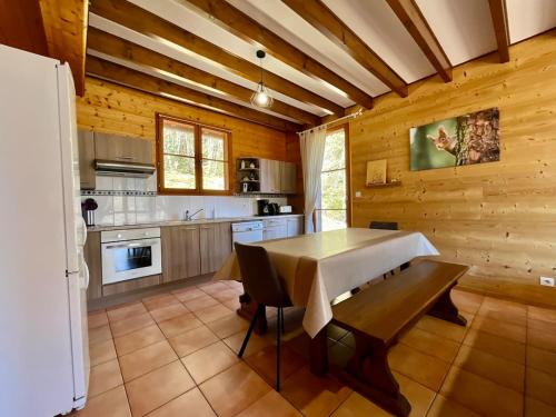 - une cuisine avec une table et un mur en bois dans l'établissement Chalet L'Ecureuil, with terrace & lake view, à Xonrupt-Longemer
