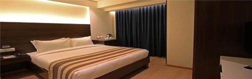 a hotel room with a bed and a window at Hotel German Palace Near to Airport in Gandhinagar