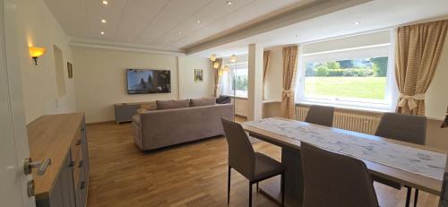 a living room with a table and a couch at Gästehaus Casa Cristina in Bad Krozingen
