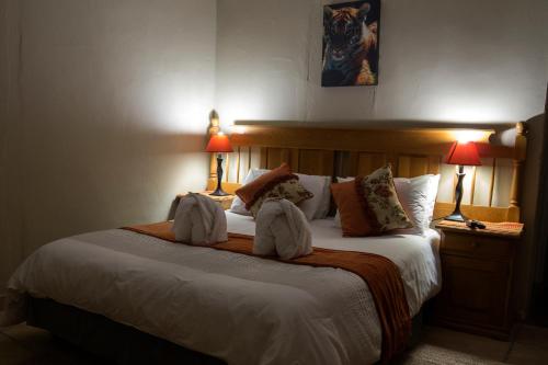 a hotel room with a bed with two towels on it at Cheetau Lodge in Ebenhaezer
