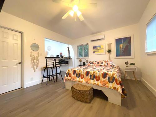 a bedroom with a bed with a comforter and a table at Tropical Paradise in Miracle Mile with Parking in Miami