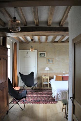 a bedroom with a bed and a desk and chairs at Doué's Mansion in Doué-la-Fontaine