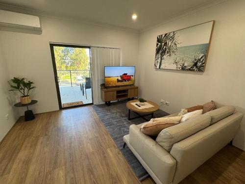 a living room with a couch and a tv at Shoreline Escape in South Beach