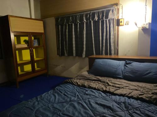 a bedroom with a bed and a book shelf at HostelBed and Art Space Phichai in Phichai